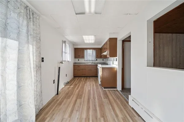 a large white kitchen with cabinets a sink and appliances