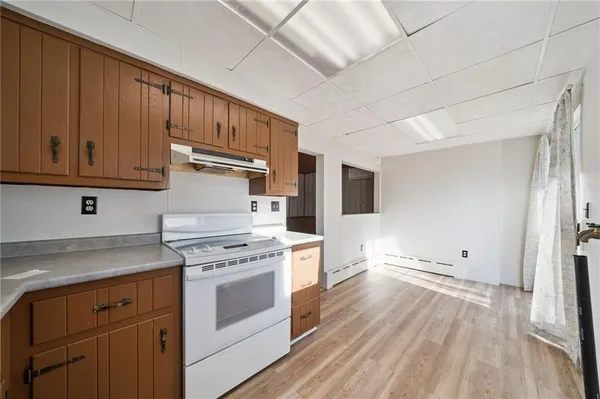 a kitchen with granite countertop wooden floors and white stainless steel appliances