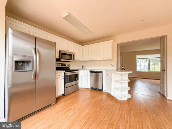 a kitchen with granite countertop a refrigerator and a stove top oven