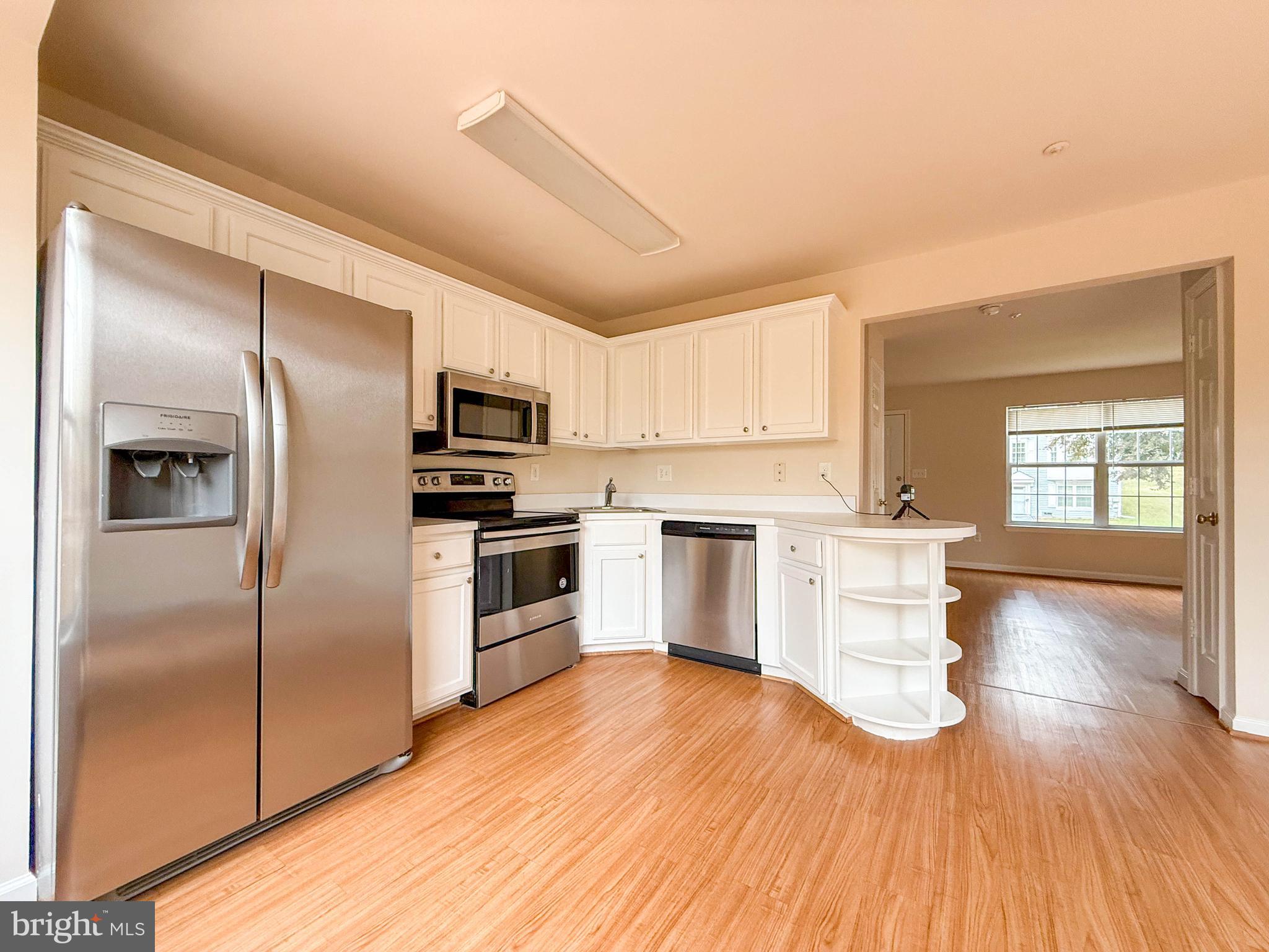 3511 Orchard Shade Road Randallstown, MD 21133 - Photo 12 of 27 a kitchen with granite countertop a refrigerator and a stove top oven