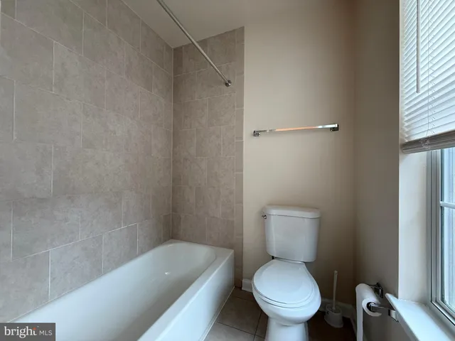 a white toilet sitting next to a bath tub