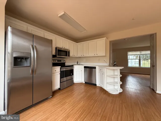 a kitchen with a refrigerator and a stove top oven
