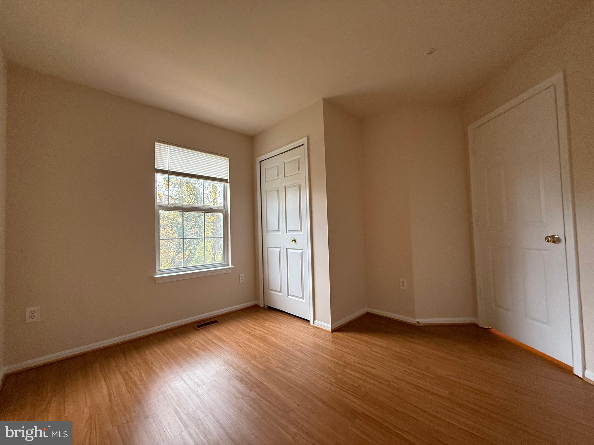 3511 Orchard Shade Road Randallstown, MD 21133 - Photo 22 of 30 an empty room with wooden floor and windows