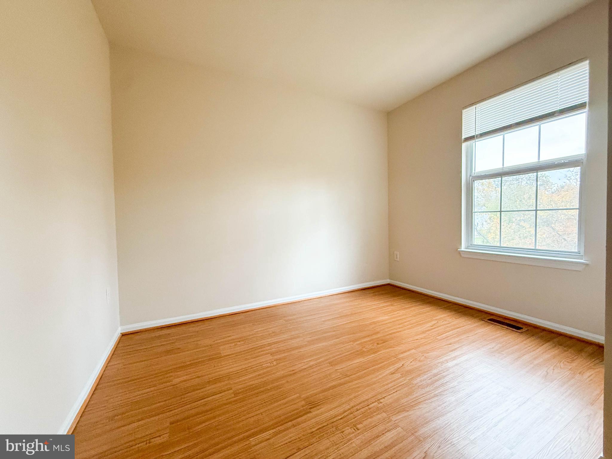 3511 Orchard Shade Road Randallstown, MD 21133 - Photo 23 of 27 an empty room with wooden floor and windows