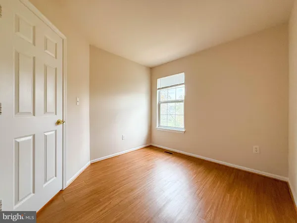 a view of a room with wooden floor and entryway