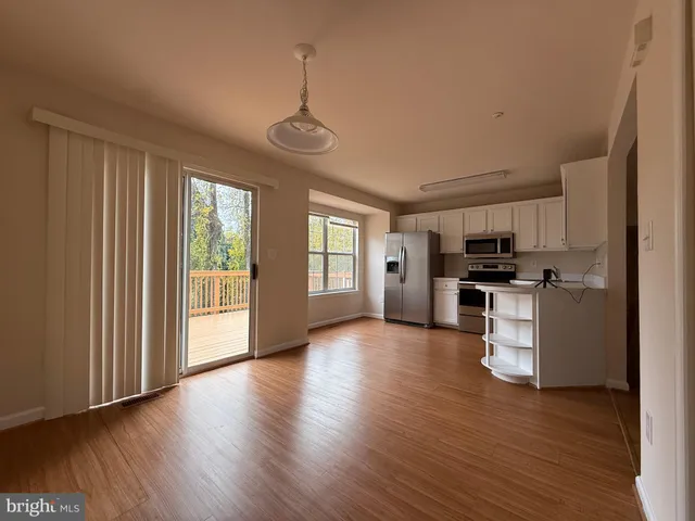 a view of kitchen with refrigerator and wooden floor
