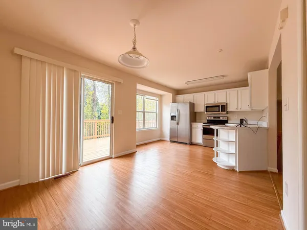 a view of kitchen with refrigerator microwave and stove top oven