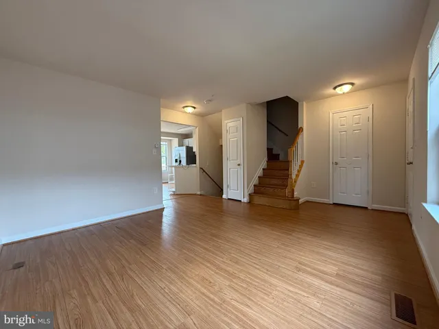 a view of a hallway with wooden floor and stairs