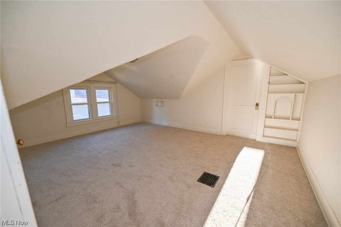 3832 Silsby Road Cleveland, OH 44111 - Photo 13 of 21 Additional living space featuring lofted ceiling and light carpet