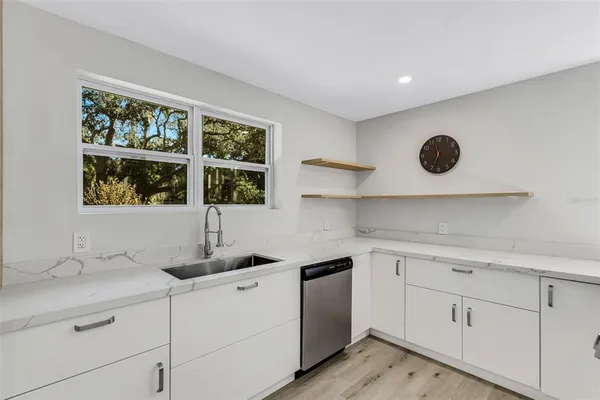 a kitchen with stainless steel appliances a dining table chairs and a refrigerator