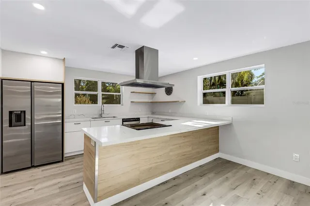 a kitchen with stainless steel appliances kitchen island granite countertop a sink and a stove