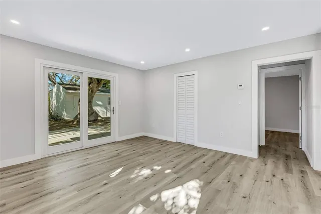 a view of a hallway with wooden floor and windows