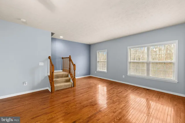 a view of a livingroom with wooden floor and a ceiling fan