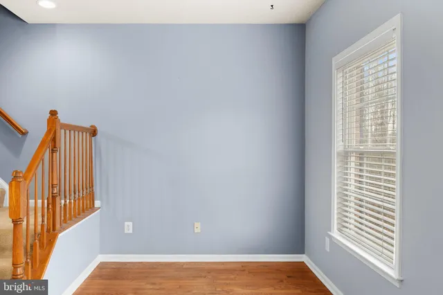 a kitchen with stainless steel appliances granite countertop a refrigerator a sink dishwasher a stove oven and a dining table with wooden floor