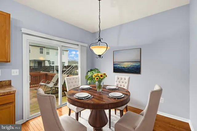 a kitchen with stainless steel appliances granite countertop a stove top oven a refrigerator and a dining table view