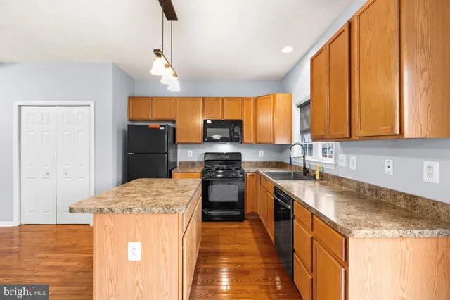 a kitchen with stainless steel appliances granite countertop a stove refrigerator sink and microwave
