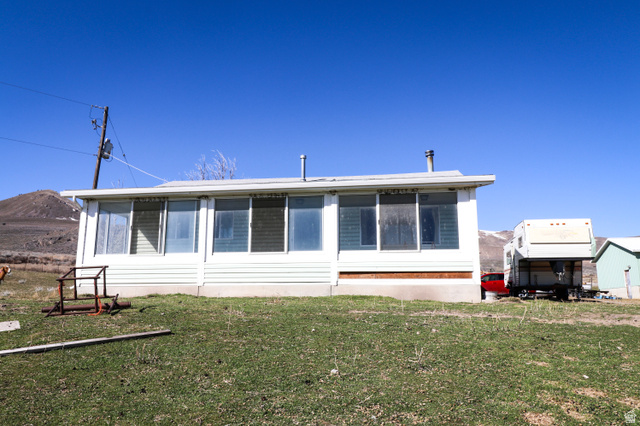 2430 North East Promontory Road Corinne, UT 84307 - Photo 1 of 1 Rear view of house with a yard and a sunroom