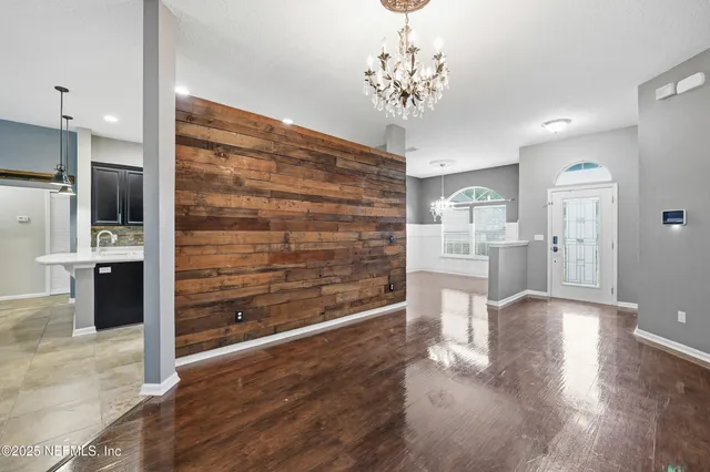 a view of a hallway with wooden floor and a chandelier