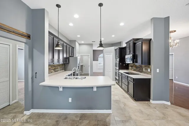 a view of kitchen with stainless steel appliances granite countertop sink stove and refrigerator