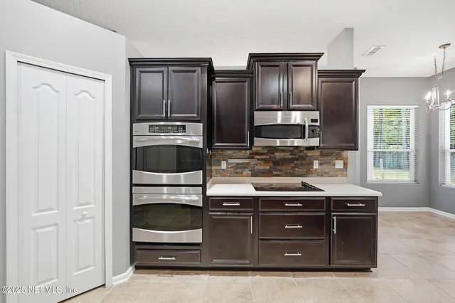 a kitchen with stainless steel appliances granite countertop a refrigerator and a stove