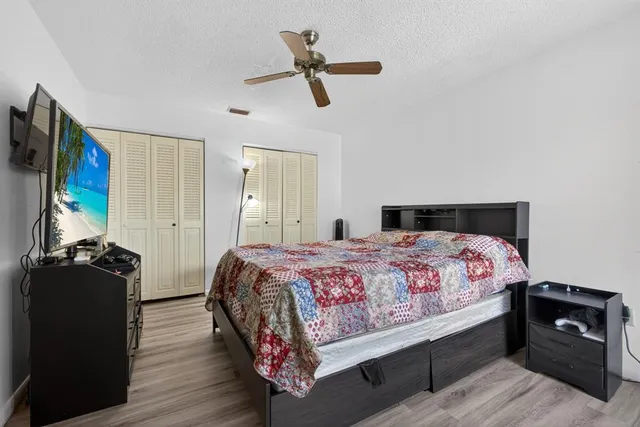 a bedroom with a bed and wooden floor