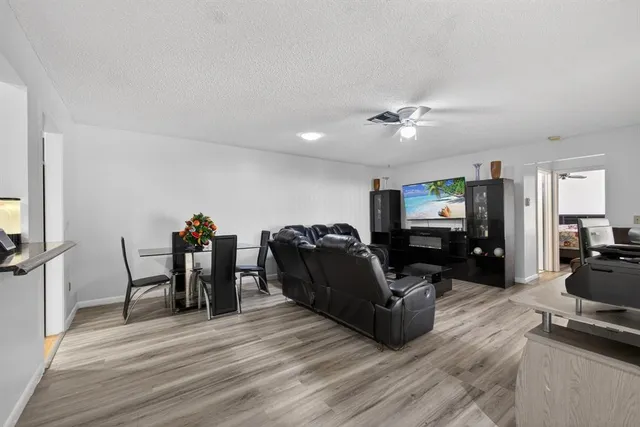 a living room with furniture a wooden floor and a flat screen tv