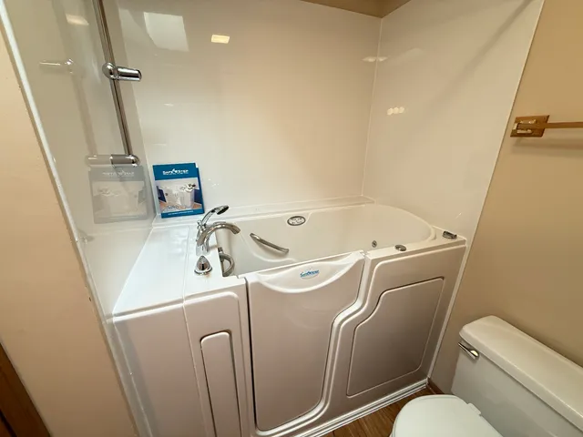 a view of a big room with a chandelier fan and windows
