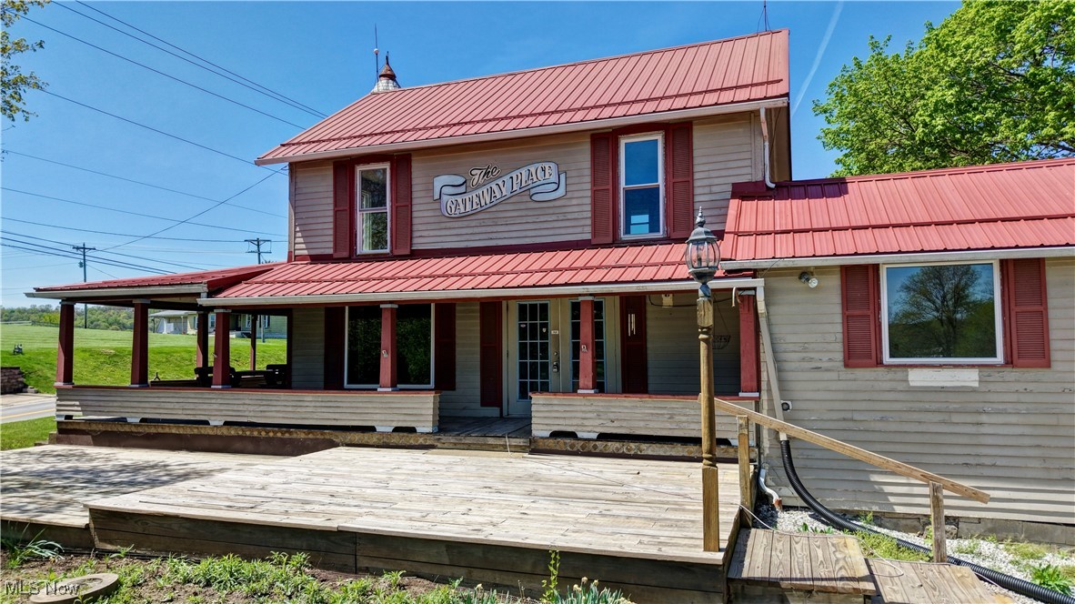 14875 Navarre Road Southwest Wilmot, OH 44689 - Photo 2 of 40 Rear view of property featuring metal roof and covered porch