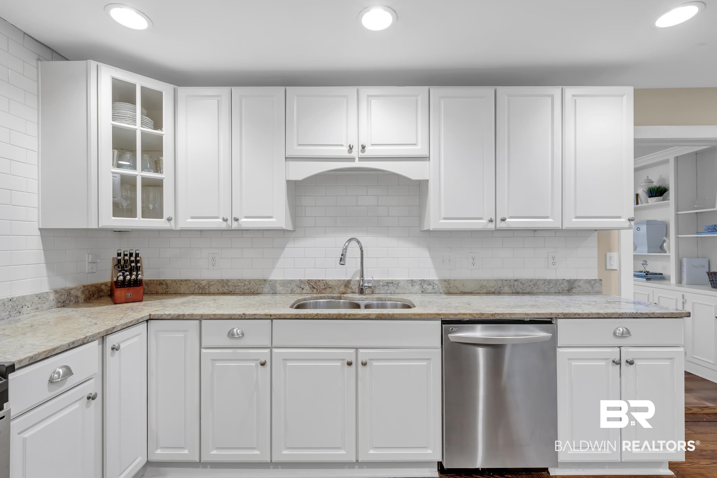 18 York Place Mobile, AL 36608 - Photo 9 of 27 Kitchen featuring white cabinets, backsplash, glass insert cabinets, stainless steel dishwasher, and light stone countertops