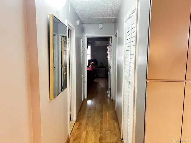 a view of a hallway with wooden floor and closet