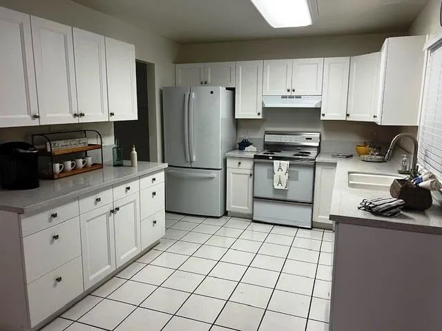 a kitchen with cabinets appliances a sink and a counter space