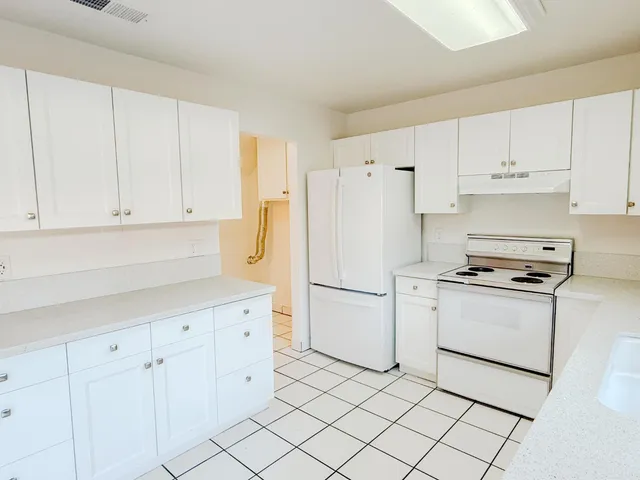 a kitchen with cabinets and white appliances