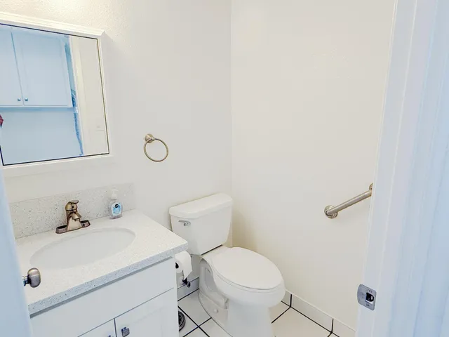 a white toilet sitting next to a white sink
