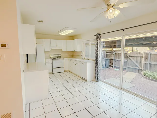 a large white kitchen with a sink and cabinets
