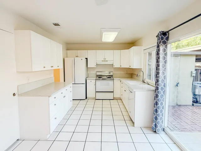 a kitchen with white cabinets and white appliances