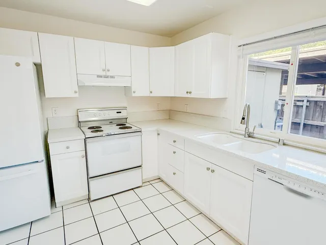 a kitchen with cabinets and white appliances