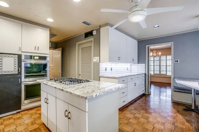 a kitchen with granite countertop a sink stove and refrigerator