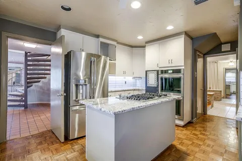 a kitchen with stainless steel appliances granite countertop a refrigerator and a stove