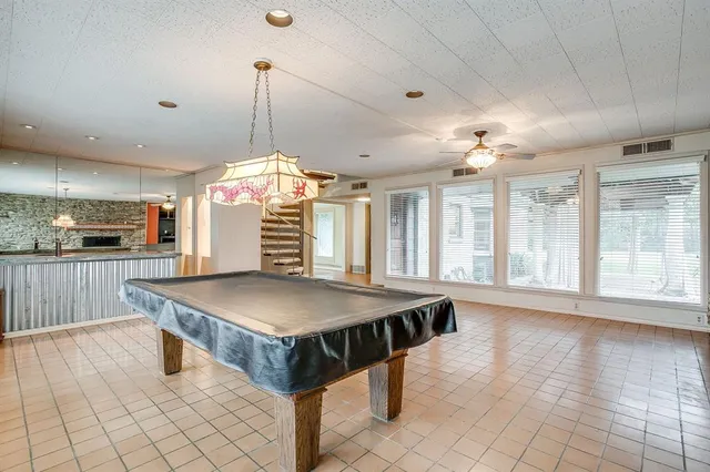 a room with pool table and windows
