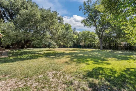 a view of a green field with wooden fence
