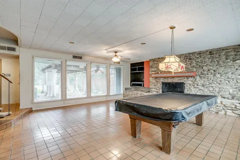 a room with pool table and windows