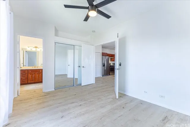 a view of a room with wooden floor and ceiling fan