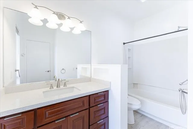 a bathroom with a sink a toilet and a large mirror
