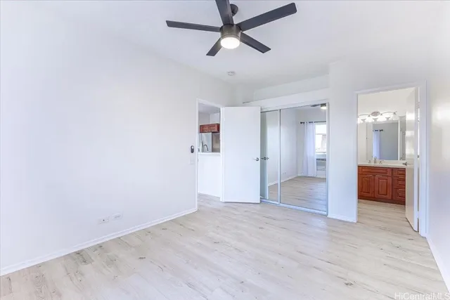 a view of a big room with wooden floor and a kitchen