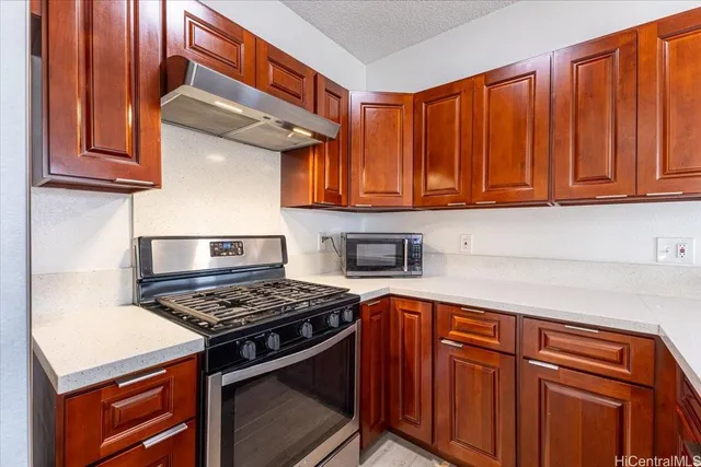 a kitchen with stainless steel appliances granite countertop a stove and a refrigerator