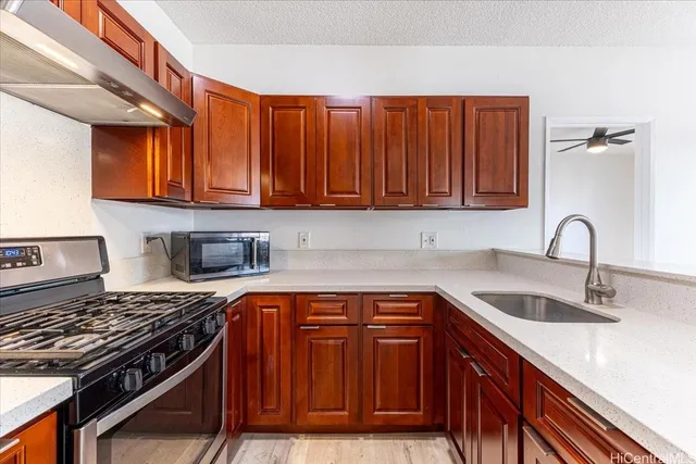 a kitchen with stainless steel appliances granite countertop a sink stove and cabinets