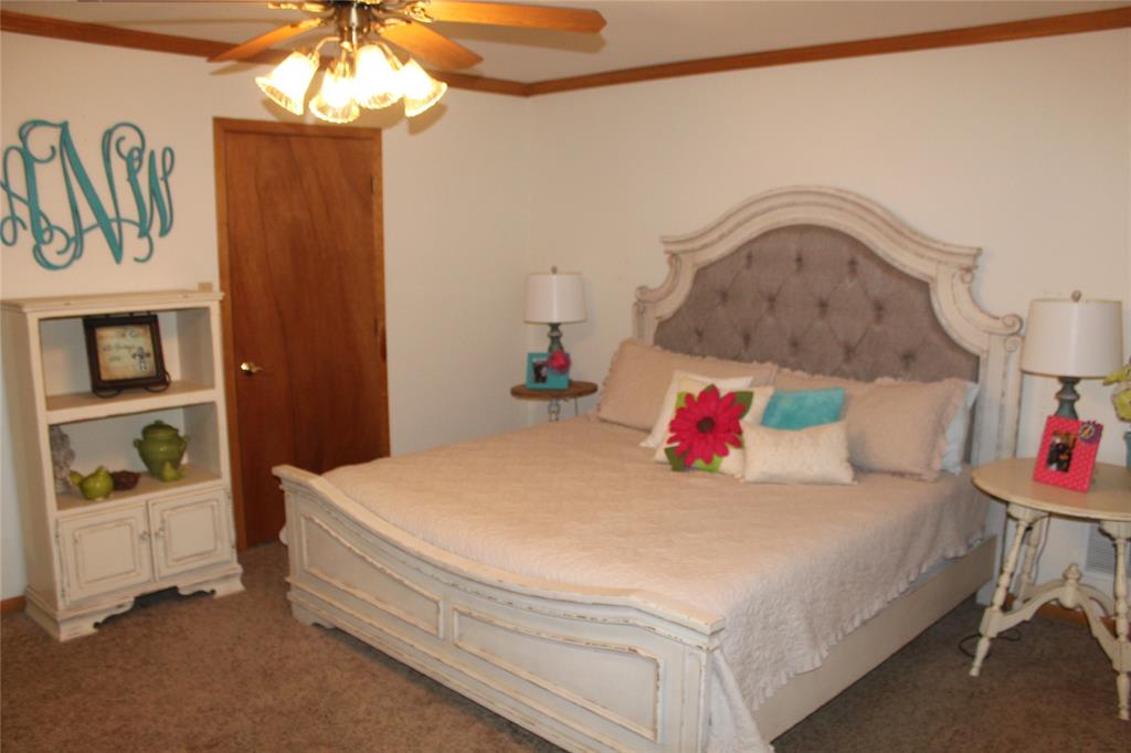 6928 Scott Street Eustace, TX 75124 - Photo 17 of 37 a bedroom with a bed and a chandelier