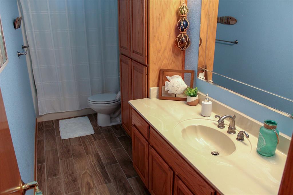 6928 Scott Street Eustace, TX 75124 - Photo 26 of 37 a bathroom with a sink and mirror with toilet