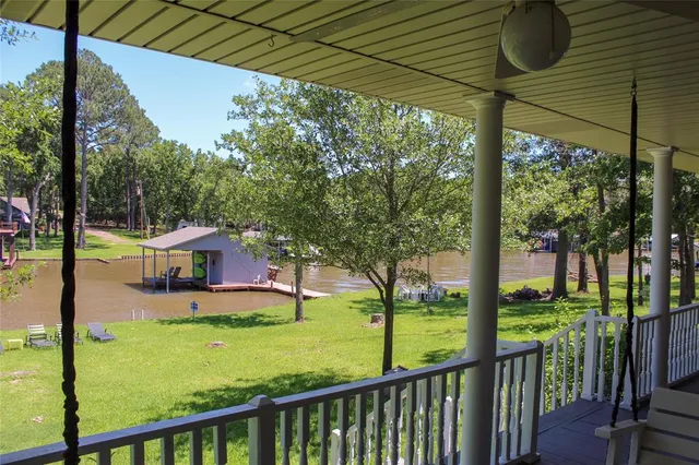 a view of a house with large trees and a yard
