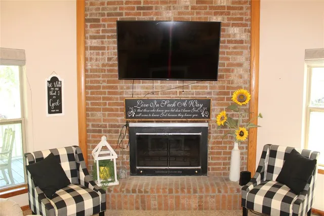 a living room with furniture a fireplace and a flat screen tv
